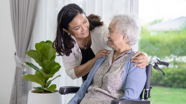 younger woman caregiving for a senior woman in a wheelchair